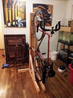 there is a bike that is on the stand in the room with other items around it