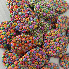 a pile of colorful donuts sitting on top of a white table next to each other