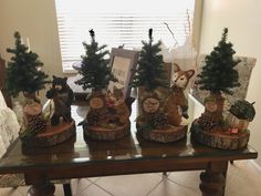 a group of figurines sitting on top of a table next to pine trees