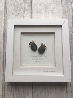 two black rocks in a white frame on a wooden surface with the words, congratulations to someone