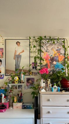 there are many pictures hanging on the wall in this room with plants and other things