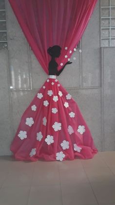 a pink dress with white flowers on it and a black figure behind the red curtain