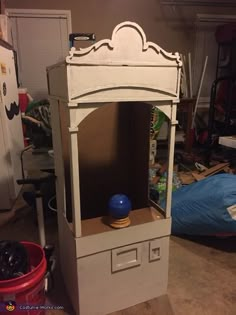 an old fashioned cabinet with a blue ball on it's top and some other items in the background