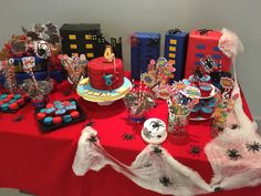 a red table topped with lots of cakes and desserts