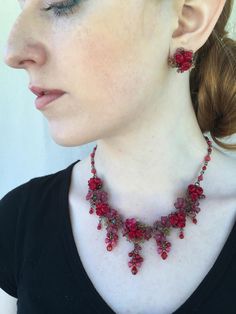 Roses are Red Necklace is so romantic. With several clusters of flowers and a poise of red roses in the center of each. This necklace is a gorgeous stunning red with a hints of green flowers that compliments the red. This piece is set off nicely with pretty red drops hanging off of each cluster. Every one needs a stunning statement red necklace in their collection. Colleen has been creating her unique style of vintage jewelry for more than 30 years. All of our pieces come with an engraved tag wi Formal Red Flower Necklace, Red Rose Jewelry For Wedding, Red Rose Design Jewelry For Wedding, Red Rose Design Jewelry For Formal Occasion, Red Rose Design Necklace For Wedding, Red Rose Design Wedding Jewelry, Formal Red Rose Design Jewelry, Formal Red Jewelry With Rose Design, Pretty Valentines