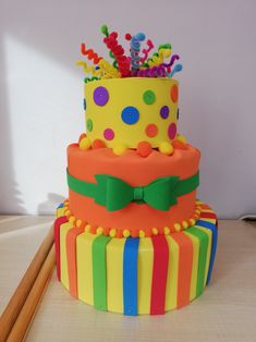 there is a multi layer cake with colorful decorations on it