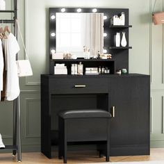 a black vanity with lights on it and a stool in front of the mirror next to it