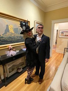 a man and woman are dressed up in fancy clothes, hats and costumes for halloween