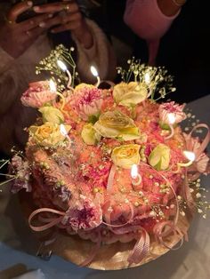 a birthday cake with candles and flowers on it