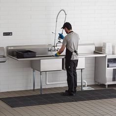 a man is washing his hands in the kitchen sink with a sprayer on it