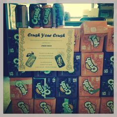 a sign that says crush your crush in front of stacks of sodas and cans