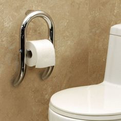 a white toilet sitting in a bathroom next to a wall mounted paper dispenser