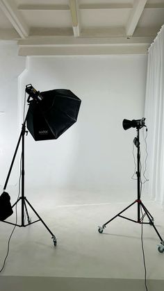 two photography equipment are set up in an empty room