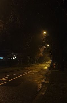 an empty street at night with no cars on the road or people in the distance