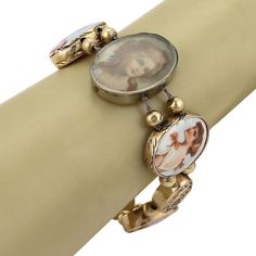 "This is a gorgeous antique bracelet, from the 1930s, it is crafted from solid 14k yellow gold featuring 8 oval shape links in assorted size, three with embossed floral design and is adorned with sapphire, emerald and diamond, five of the oval frame links are with handpainted porcelain cameo of 16th Century women in various dress style. Each oval link is separated by two gold balls on a double chain which fastens with a push in clasp with latch for added security. Metal: 14k yellow gold Hallmark Vintage Gold Rosary Bracelet Gift, Vintage Gold Rosary Bracelet As A Gift, Vintage Gold Rosary Bracelet For Gift, Vintage Oval Link Gold Bracelet As Gift, Vintage Adjustable Oval Link Bracelets, Antique Oval Gold Bracelet, Vintage Adjustable Bracelet With Oval Links, Vintage Oval Gold Bracelet Gift, Antique Oval Cameo Bracelet