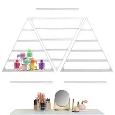 a shelf with makeup and cosmetics on it in front of a wall mounted triangle mirror