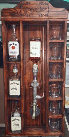 an old fashioned liquor dispenser with glasses in it