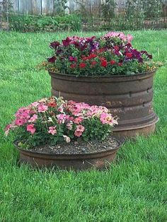 two flower pots sitting in the grass near each other