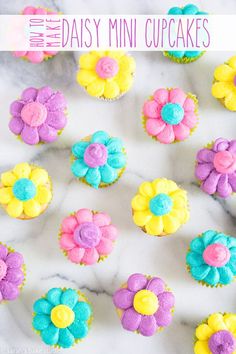 cupcakes decorated with colorful frosting and flowers on a marble counter top, ready to be eaten