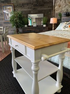 a bed room with a neatly made bed and a wooden table in front of it