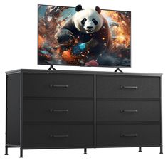 a large television on top of a dresser next to a panda bear wall hanging above it