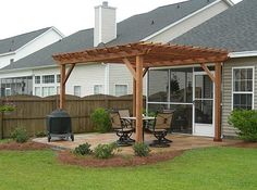 a backyard with a grill and patio furniture