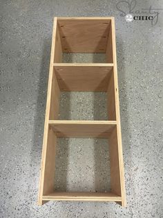 a wooden shelf sitting on top of a cement floor