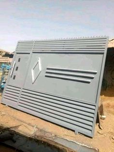 a large metal box sitting on top of a dirt field