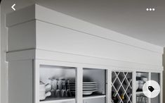 a kitchen with white cupboards and dishes on the shelves in front of the counter