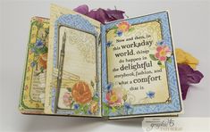 an open book with flowers and writing on it