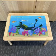 a child's wooden table with an underwater scene painted on it