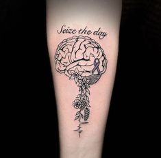 a black and white tattoo with a brain on the left side of the leg that says, jeze the day