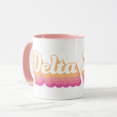 a pink and white coffee mug with the word delta on it