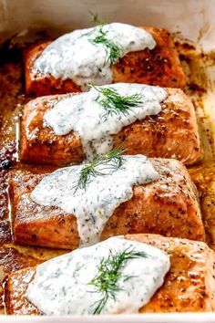 four salmon patties covered in white sauce and dill sprinkled on top