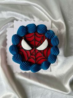 a close up of a spiderman cake on a white cloth