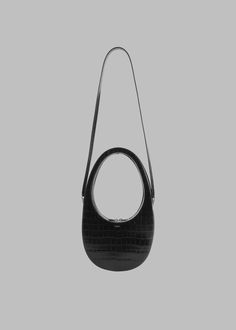 Color: Black Soft grained leather Oval shaped bag Detachable leather strap Silver-foil print logo Woven flag label on side Double ended zip closure Option to style as a hand or shoulder bag 100% Calf Leather By Coperni. Made in Italy Black Leather Hobo Bag With Adjustable Handle, Business Shoulder Bag With Removable Pouch And Round Handle, Black Round Handle Business Bags, Black Textured Leather Bag With Round Handle, Daily Use Textured Leather Shoulder Bag With Round Handle, Black Leather Bucket Bag With Adjustable Handle, Silver Foil Printing, Silver Foil, Oval Shape