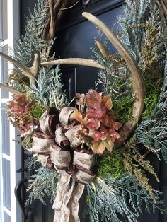 a wreath with deer antlers and pine cones