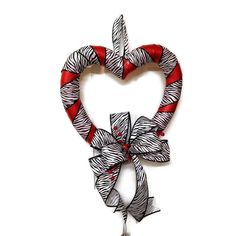 a red and white heart shaped decoration hanging on a wall