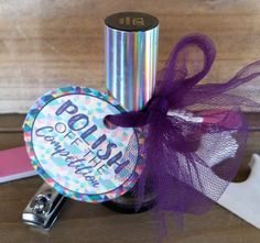 a bottle with a purple bow on it sitting next to some scissors and other items