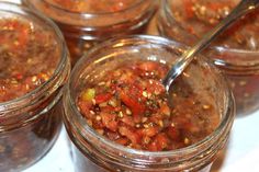 several jars filled with different types of food and one has a spoon in the jar