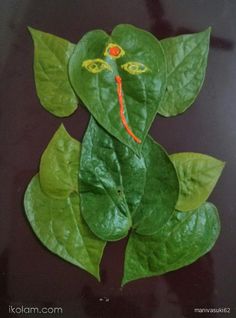 a green leaf with a face drawn on it