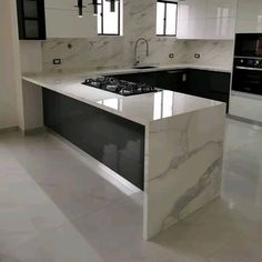 a kitchen with marble counter tops and black appliances in the background, along with white tile flooring