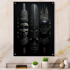 three african masks hanging on a wall