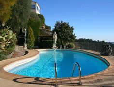 an empty swimming pool surrounded by greenery