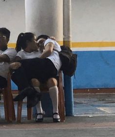 three people sitting on chairs with their backs to each other and one person leaning against the chair