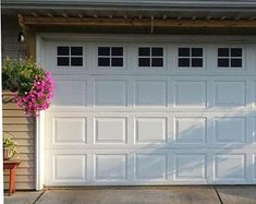 a white garage door with flowers in the window