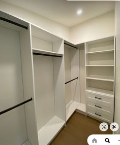 an empty walk in closet with white shelves and drawers