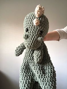 a crocheted stuffed animal being held by someone