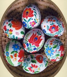 an arrangement of painted eggs in a wicker basket