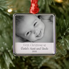 a baby's first christmas as an ornament hanging from a christmas tree